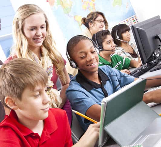 Pre-teen students in computer lab with instructor. Classroom, school, education.