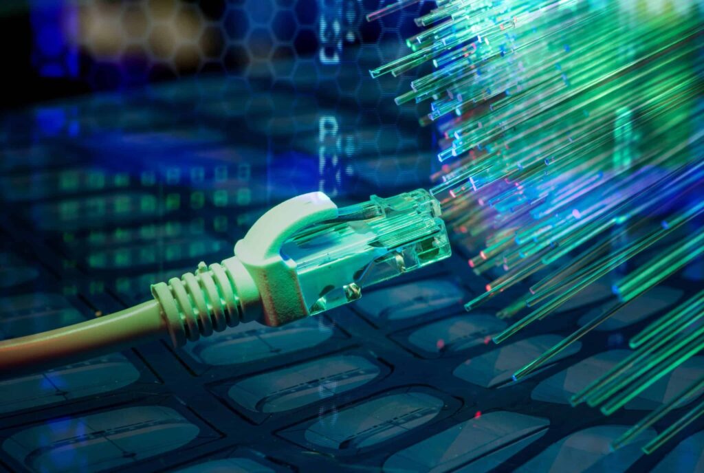 A close-up view of a network cable connector emitting vibrant streaks of light, symbolizing high-speed fiber optic internet and advanced digital communication technology.